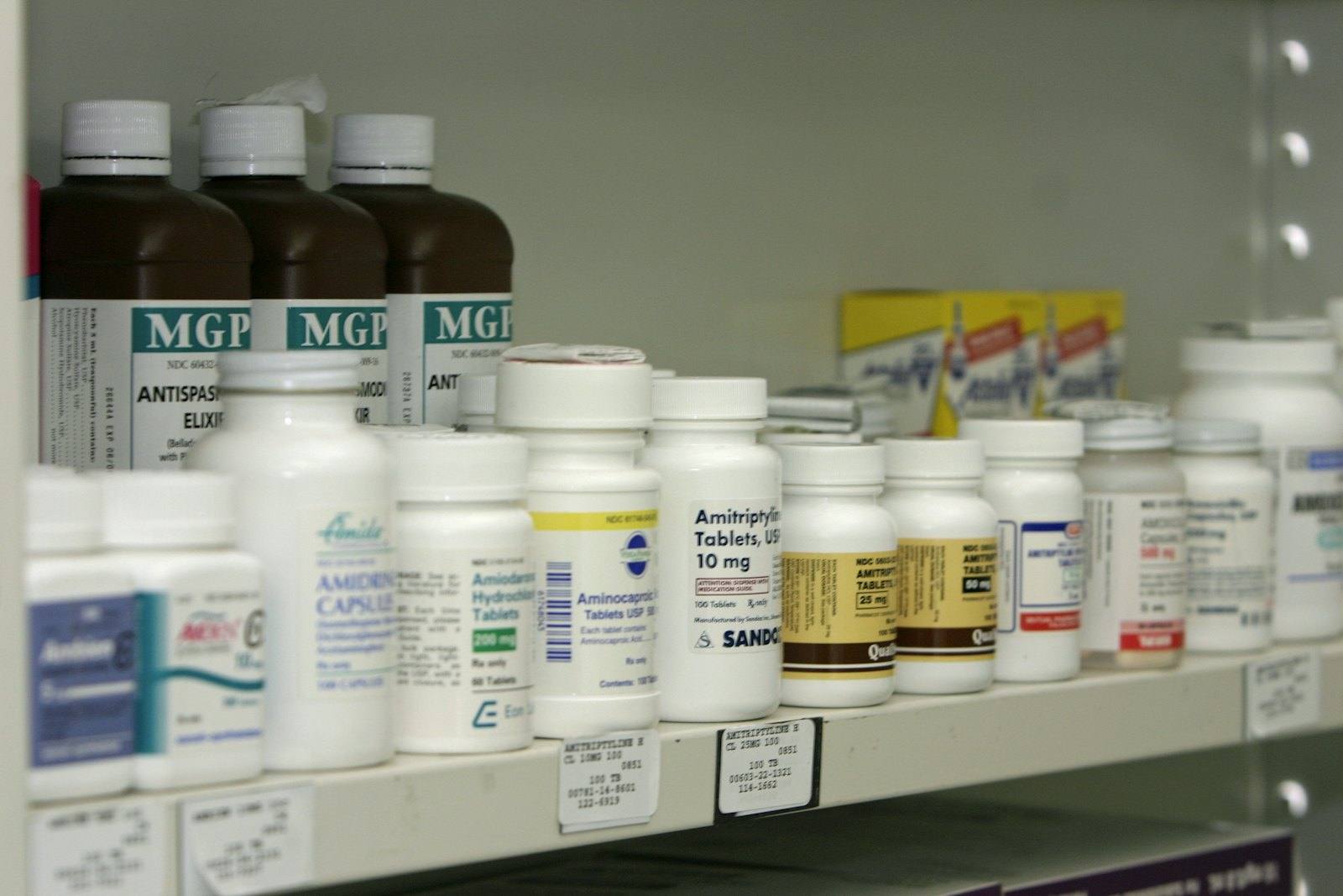 Pharmacy shelf of labelled medicine bottles